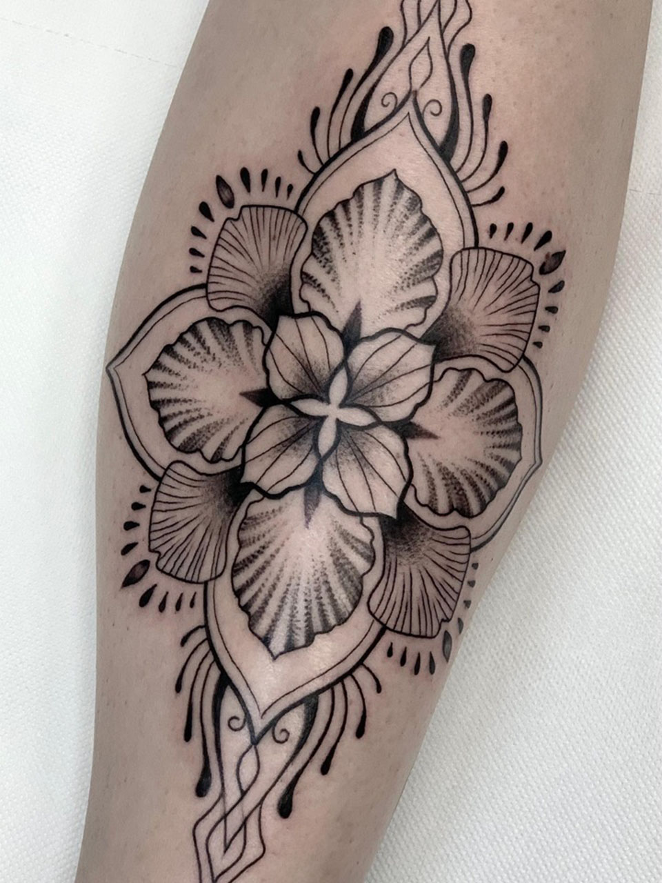 tatauje ornamental flor tinta negra linea fina y linea gruesas tibia